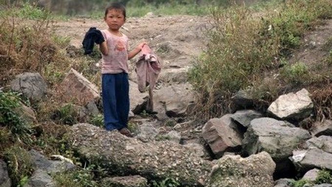 Chlapec nese oblečení ve městě Sinujiu na severokorejské straně řeky Ja-lu, která odděluje Severní Koreu od Číny
