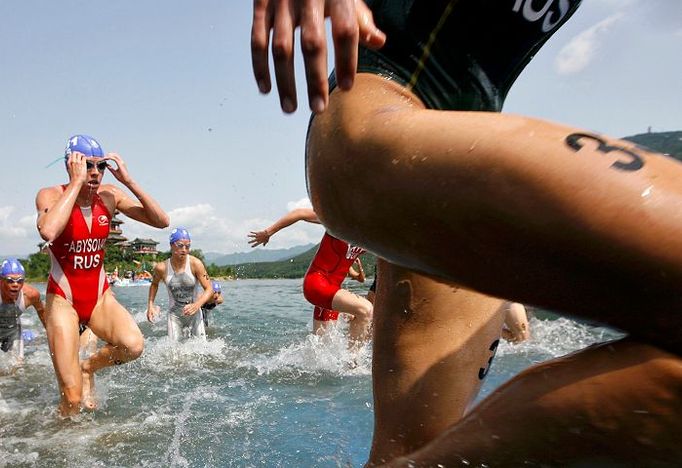 Triatlon. Závodnice vybíhající z vody v jezeře Ming Tomb severně od Pekingu během ženského triatlonu na olympijských hrách v Číně.