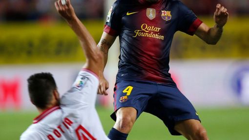 Fotbalista Barcelony Cesc Fabregas bojuje o míč s Tomasem Albertem Boatiou v utkání španělské La Ligy 2012/13 se Sevillou.