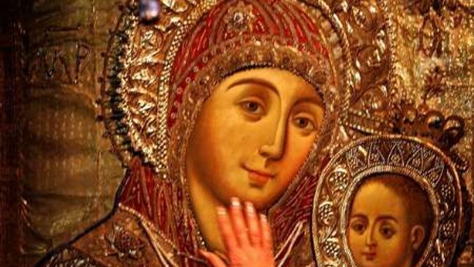 Poutník v Chrámu narození Páně v Betlémě se dotýká ikony zobrazující Pannu Marri a Ježíše.