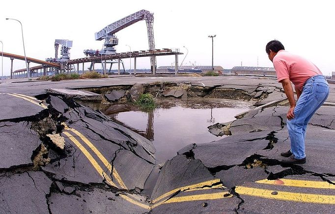 A man at Taichung Port, 170-km southwest of Taipei, looks at a quake-opened sinkhole, 25 September 1999, that is filled with molasses spilled from nearby storage tanks destroyed in the September 21 earthquake. Officials say it will take three to six months to put three wharves back into operation. (ELECTRONIC IMAGE)