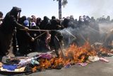 Na hlavní ulici v Saná rozprostřely ženy své šaty a šátky, polily je benzinem a zapálily.