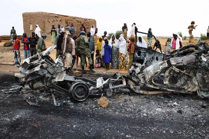 Residents look at the remains of vehicles which they said belonged to radical Islamist group MUJAO, after they were hit by French air strikes in the town of Gao January 27, 2013. Picture taken January 27, 2013. REUTERS/Adama Diarra (MALI - Tags: CIVIL UNREST MILITARY POLITICS TPX IMAGES OF THE DAY) Published: Led. 31, 2013, 5:25 dop.