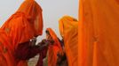 Hindu devotees apply oil on their bodies after taking a holy dip in river Ganges ahead of "Kumbh Mela" (Pitcher Festival) in the northern Indian city of Allahabad January 12, 2013. During the festival, Hindus take part in a religious gathering on the banks of the river Ganges. "Kumbh Mela" will return to Allahabad in 12 years. REUTERS/Ahmad Masood (INDIA - Tags: RELIGION SOCIETY) Published: Led. 12, 2013, 3:26 odp.