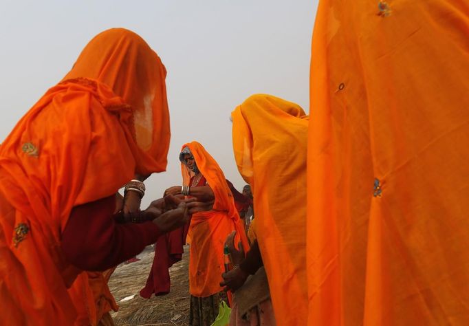 Hindu devotees apply oil on their bodies after taking a holy dip in river Ganges ahead of "Kumbh Mela" (Pitcher Festival) in the northern Indian city of Allahabad January 12, 2013. During the festival, Hindus take part in a religious gathering on the banks of the river Ganges. "Kumbh Mela" will return to Allahabad in 12 years. REUTERS/Ahmad Masood (INDIA - Tags: RELIGION SOCIETY) Published: Led. 12, 2013, 3:26 odp.