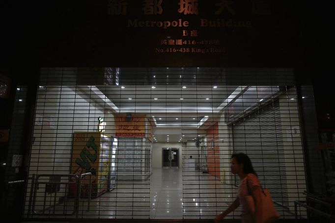 A woman walks in front of a building in which one of the apartments is composed of wooden boxes, that is lived in by people, in central Hong Kong October 9, 2012. In Hong Kong's middle-class residential area, short distance from its shopping and financial districts, 24 people live in these wooden boxes, or "coffin homes", packed in a single apartment of little over 50 square meters. Its residents pay 1450 Hong Kong dollars ($180) for their living space built of wooden panels of 2 meters by 70 cm. To maximize income from the rent in central Hong Kong landlords build "coffin homes", nicknamed due to their resemblance to real coffins. Space has always been at a premium in Hong Kong where developers plant high-rises on every available inch. REUTERS/Damir Sagolj (CHINA - Tags: SOCIETY REAL ESTATE BUSINESS) Published: Říj. 9, 2012, 2:06 odp.