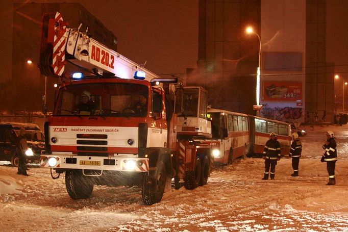 Hasiči v Praze 6 ulici Makovského vyprošťují autobus, který se zasekl v tramvajových kolejích