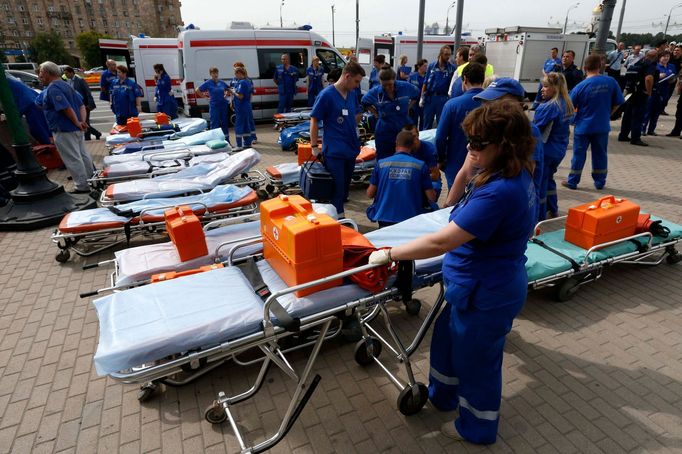 Záchranáři čekají po vykolejení vagonu v moskevském metru na příjem zraněných. (15. července 2014)