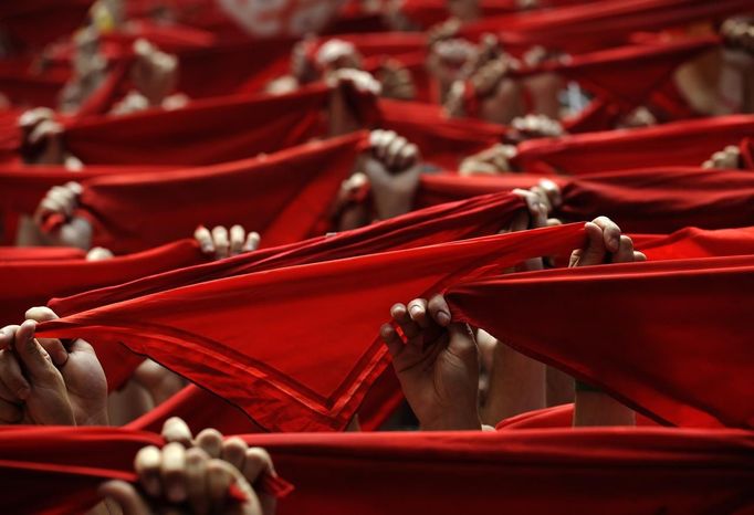 Revellers hold up their red scarves during the start of the San Fermin Festival in Pamplona July 6, 2012. The annual festival, best known for its daily running of the bulls, kicked off on Friday with the traditional "Chupinazo" rocket launch and will run until July 14. REUTERS/Eloy Alonso (SPAIN - Tags: SOCIETY ANNIVERSARY) Published: Čec. 6, 2012, 11:59 dop.