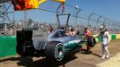 Mercedes Formula One driver Lewis Hamilton of Britain stands beside his car as it is being craned off the track during the first practice session of the Australian F1 Gra