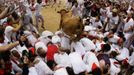 A wild cow leaps over a group of revellers following the second day of the running of the bulls at the bullring during the San Fermin festival in Pamplona July 8, 2012. Various runners suffered light injuries in a run that lasted two minutes and twenty-eight seconds, according to the Navarran government press office. REUTERS/Joseba Etxaburu (SPAIN - Tags: ANIMALS SOCIETY) Published: Čec. 8, 2012, 9:32 dop.