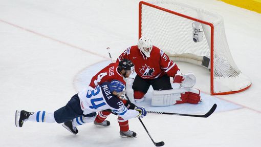 Finland's Olli Palola and Canada's Ryan Ellis chase the puck in front of Canada's goalie Ben Scrivens during the first period of their men's ice hockey World Championship
