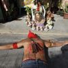 REFILE - ADDING ADDITIONAL CAPTION INFORMATION A hooded penitent with a bloodied back prays while lying on his belly in front of an image of Jesus Christ during Maundy Thursday Lenten rites in Mandaluyong city, metro Manila March 28, 2013. Maundy Thursday or Holy Thursday is the day Christians commemorate the Last Supper of Jesus Christ. Holy Week is celebrated in many Christian traditions during the week before Easter. REUTERS/Romeo Ranoco (PHILIPPINES - Tags: POLITICS RELIGION SOCIETY TPX IMAGES OF THE DAY) Published: Bře. 28, 2013, 5:57 dop.