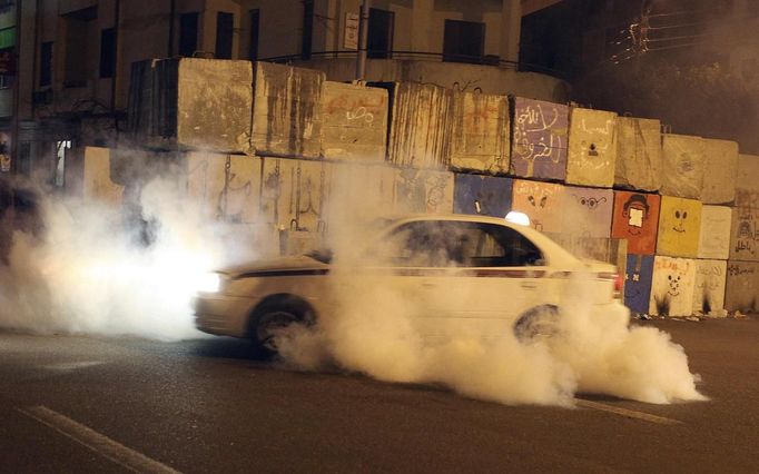 A taxi tries to find its way out as it gets caught in tear gas fired by police on protesters during clashes near the Presidential Palace in Cairo February 11, 2013. Protesters demanding the departure of Egyptian President Mohamed Mursi clashed with police outside his palace on Monday on the second anniversary of the overthrow of veteran autocrat Hosni Mubarak. Dozens of youths threw rocks at the Ettihadiya palace after a peaceful march by thousands of demonstrators who accused Mursi's conservative Muslim Brotherhood of hijacking Egypt's democratic revolution and seeking to monopolise power. REUTERS/Asmaa Waguih (EGYPT - Tags: POLITICS CIVIL UNREST) Published: Úno. 11, 2013, 8:47 odp.