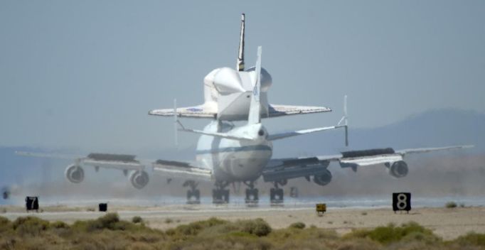 The space shuttle Endeavour, carried piggyback atop a Boeing 747 jumbo jet, comes in for its landing at at Edwards Air Force Base in California, September 20, 2012, after a cross-country trip to Los Angeles to begin its final mission as a museum exhibit. Endeavour is scheduled to take off for its final ferry flight again on Friday, and the final airborne journey of the entire space shuttle fleet, headed for Los Angeles International Airport. REUTERS/Gene Blevins (UNITED STATES - Tags: TRANSPORT SCIENCE TECHNOLOGY) Published: Zář. 20, 2012, 10:15 odp.