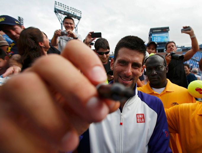 Srbský tenista Novak Djokovič se podapisuje na objektiv po výhře nad Švýcarem Stanislasem Wawrinkou na US Open 2012.