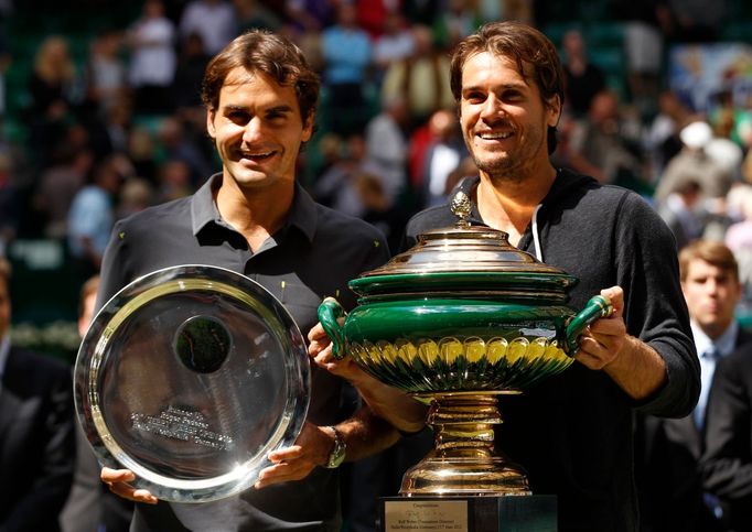 Německý tenista Tommy Haas pózuje s trofejí po vítězství na turnaji ATP v německém Halle. Vedle něj finalista Švýcar Roger Federer (vlevo).