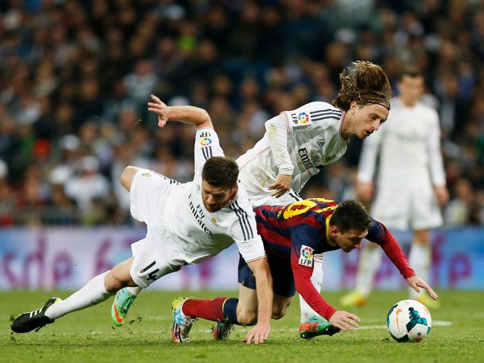 Barcelona's Messi and Real Madrid's Alonso and Modric challenge for ball during La Liga's second 'Clasico' soccer match of the season in Madrid