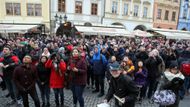 Všichni turisté čekají, až na orloji odbije jedna.