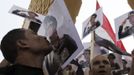 A man kisses a poster of late Egyptian President Sadat as supporters of army shout slogans against ousted Islamist President Mursi and members of the Muslim Brotherhood in Cairo