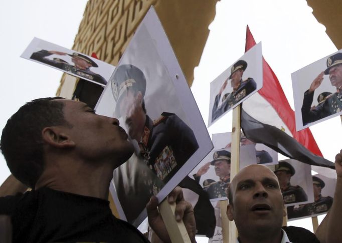 A man kisses a poster of late Egyptian President Sadat as supporters of army shout slogans against ousted Islamist President Mursi and members of the Muslim Brotherhood in Cairo