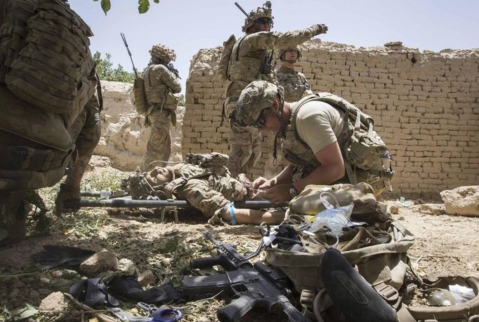 U.S. Army soldiers secure an area, as a medic treats Sgt. Matt Krumwiede who was wounded by an improvised explosive device (IED) in southern Afghanistan June 12, 2012. On June 12, 2012, Krumwiede was on patrol in Afghanistan when he stepped on an IED, which tore away both his legs, damaged his left arm, and ripped open his abdominal cavity. The 22-year-old has since undergone around 40 surgeries and is learning to walk with prosthetic legs. He is keen to re-join the infantry as soon as his injuries allow. U.S. troops have been in Afghanistan since 2001. Thousands of Afghan elders gathered in Kabul on November 21, 2013 at a Loya Jirga, or grand council, to debate a crucial security pact with the United States, a day after Kabul and Washington reached a draft agreement laying out the terms under which U.S. troops may stay beyond 2014. Picture taken June 12, 2012.