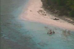 Trosečníky na pustém ostrově našli záchranáři díky nápisu "pomoc" v písku