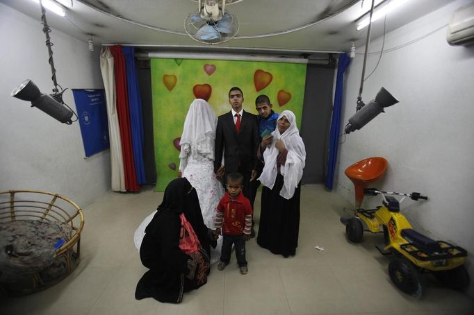 Palestinian groom Emad al-Malalha, 21, poses for a photograph with Manal Abu Shanar, 17, his Egyptian bride, and his relatives after the couple's arrival from a smuggling tunnel at a studio in Rafah in the southern Gaza Strip March 21, 2013. Al-Malaha , who said that his bride was not given a permit from Egyptian authorities to enter the Gaza Strip, brought her from neighboring Egypt through a smuggling tunnel to celebrate his wedding in his native Gaza Strip. REUTERS/Ibraheem Abu Mustafa (GAZA - Tags: POLITICS SOCIETY) Published: Bře. 21, 2013, 6:27 odp.