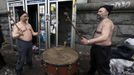 Two anti-government protesters use a large drum after violence erupted in the Independence Square in Kiev February 20, 2014. Ukrainian protesters hurling petrol bombs and