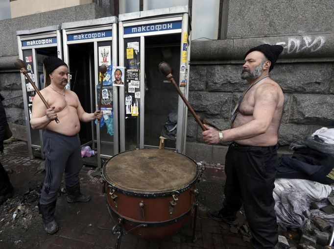 Two anti-government protesters use a large drum after violence erupted in the Independence Square in Kiev February 20, 2014. Ukrainian protesters hurling petrol bombs and