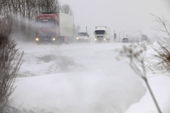 High winds blow snow as lorries make their way on road in Vicogne between Doullens and Amiens, northern France, March 11, 2013. Winter weather with snow and freezing temperatures returns to France. REUTERS/Pascal Rossignol (FRANCE - Tags: ENVIRONMENT) Published: Bře. 11, 2013, 4:03 odp.