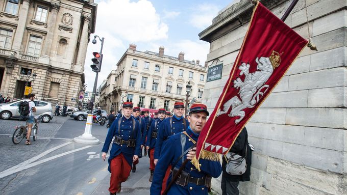 Muži z Čs. obce legionářské pochodují ulicemi Paříže v dobových francouzských uniformách.