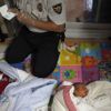 A police officer collects DNA samples from two abandoned babies after the babies were left at a "baby box" at Joosarang church in Seoul September 20, 2012. A South Korean pastor of the church who runs a "baby box" where mothers can leave unwanted infants has seen a sharp increase in the number of newborns being left there because, the pastor says, of a new law aimed protecting the rights of children. South Korea is trying to shed a reputation of being a source of babies for adoption by people abroad. It is encouraging domestic adoption and tightening up the process of a child's transfer from birth mother to adoptive parents. Picture taken September 20, 2012. REUTERS/Kim Hong-Ji (SOUTH KOREA - Tags: SOCIETY TPX IMAGES OF THE DAY) Published: Říj. 7, 2012, 7:31 dop.