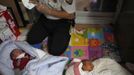 A police officer collects DNA samples from two abandoned babies after the babies were left at a "baby box" at Joosarang church in Seoul September 20, 2012. A South Korean pastor of the church who runs a "baby box" where mothers can leave unwanted infants has seen a sharp increase in the number of newborns being left there because, the pastor says, of a new law aimed protecting the rights of children. South Korea is trying to shed a reputation of being a source of babies for adoption by people abroad. It is encouraging domestic adoption and tightening up the process of a child's transfer from birth mother to adoptive parents. Picture taken September 20, 2012. REUTERS/Kim Hong-Ji (SOUTH KOREA - Tags: SOCIETY TPX IMAGES OF THE DAY) Published: Říj. 7, 2012, 7:31 dop.