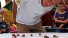 World Snail Racing Championships in Congham, Norfolk, Britain - 18 Jul 2010 2010-07-18 00:00:00 Mandatory Credit: Photo by Geoffrey Robinson / Rex Features ( 1208528d ) Snailmaster Neil Risborough keeping an eye on the snails World Snail Racing Championships in Congham, Norfolk, Britain - 18 Jul 2010 More than 200 snails slugged it out at the annual World Snail Racing Championships in a tiny Norfolk village this weekend. The garden snails spent Saturday afternoon sliming over a challenging 13 inch course to win a silver tankard stuffed with lettuce. The quirky competition, which has been running for nearly 40 years, is held in Congham, near King's Lynn in Norfolk and attracts thousands of spectators every year. Although there are a number of imitations, it is the only recognised World Championship. This year saw its oldest ever winner with a snail belonging to 62-year-old Claire Lawrence, from Litcham in Norfolk, coming first. Her snail, named Sidney, crossed the finishing line in 3.41 minutes. "I'm shell shocked my mum has won, as it's the first time she has entered," said her son Harry Lawrence, 21, from Litcham. "She selected Sidney a couple of days ago and she has been training him in our garden and feeding him on a diet of rocket salad." The championships are part of Congham fete and were originally started to help raise money for the 13th century village church. Today it attracts hundreds of entrants of all ages, many whom have spent days training their snails for the big event. "Congham is ideal snail breeding and racing country as they like damp conditions and the village sits in a low-lying area surrounded by ponds," said organiser Hilary Scase. "People love coming along because it is quirky and something different "A lot of the children like to choose their snails a long time in advance and train them. "Surprisngly the snails seem to respond to being talked to and small snails seem to do better as they have smaller shells so they ca... For more information visit http://www.rexfeatures.com/stacklink/EPKKVYUIW