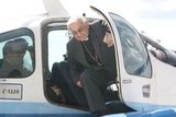Kardinál Miloslav Vlk vystupuje z letadla L-200 Morava po vyhlídkovém letu nad Prahou a Čechami, který dostal ke svým 75. narozeninám.