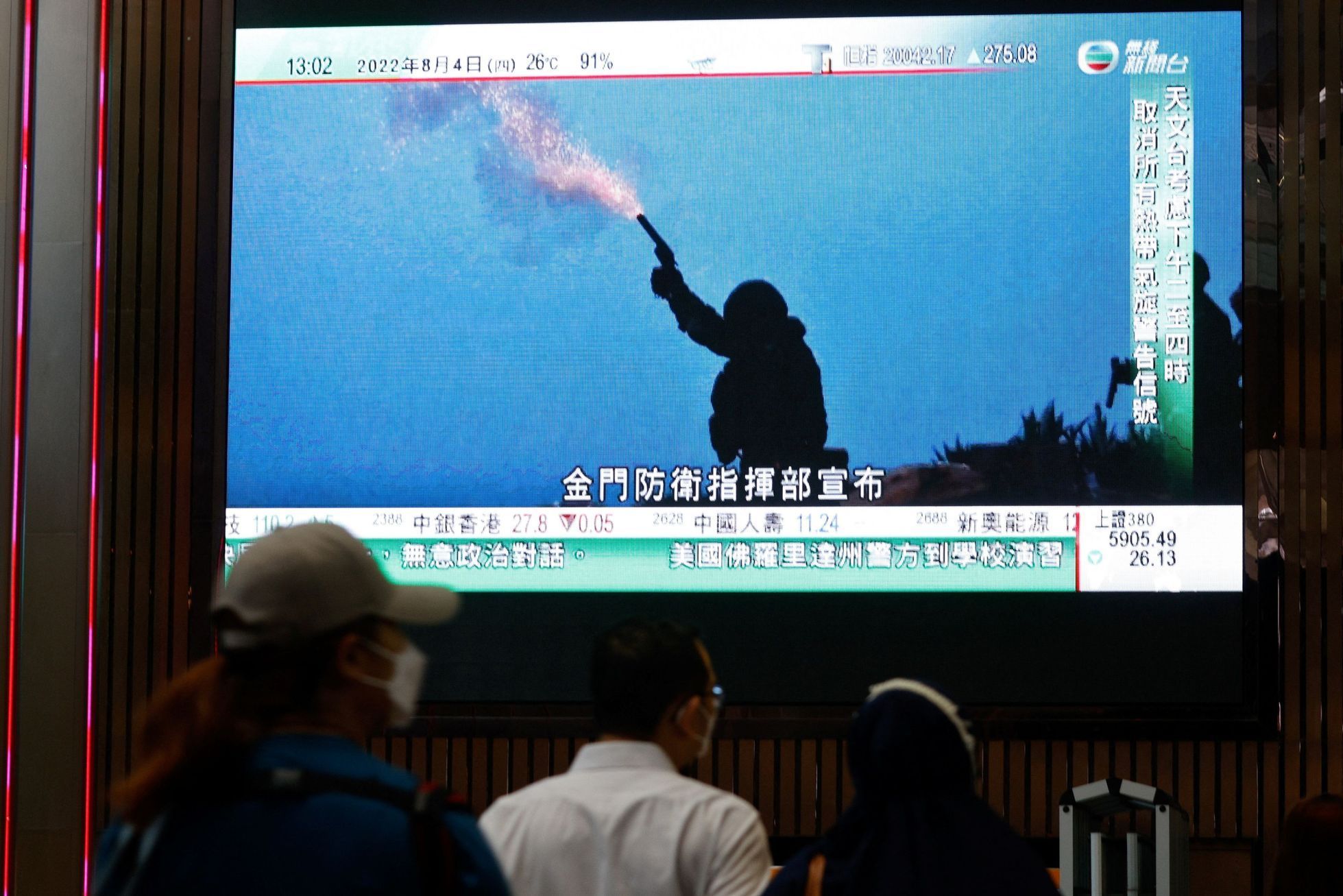 Na velkoplošné obrazovce sledují čínské manévry u Tchaj-wanu také lidé v Hongkongu..