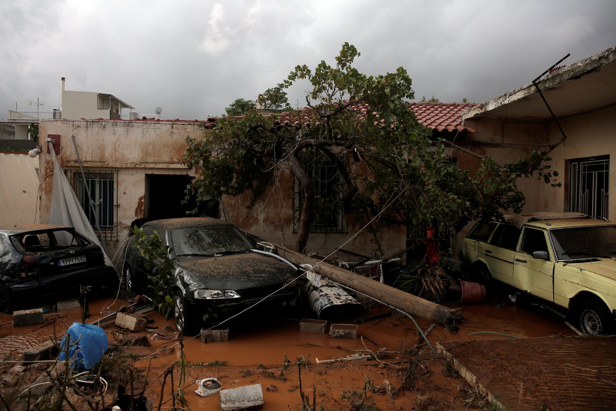 Po bouři a lijácích v řeckém městě Mandra jsou zničené domy i auta.