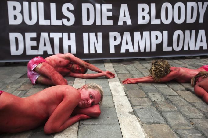 Animal rights protesters lie covered in fake blood as they form the words "Stop bullfighting" during a demonstration calling for the abolition of bull runs and bullfights, a day before the start of the famous running of the bulls San Fermin festival, in Pamplona July 5, 2012. The annual week-long fiesta gets underway July 6, with the first bull run in the morning of July 7. REUTERS/Susana Vera (SPAIN - Tags: CIVIL UNREST SOCIETY POLITICS) Published: Čec. 5, 2012, 12:07 odp.