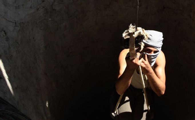 23 Titulek: Gaza's tunnel mugglers on Egypt border mostly idle Popis: A Palestinian tunnel-digger lowers himself into the smuggling tunnel beneath the Egyptian-Gaza border in Rafah in the southern Gaza, October 8, 2013. Gaza's tunnel smugglers along the border with Egypt are mostly idle these days. Since the summer, Egypt's military has tried to destroy or seal off most of the smuggling tunnels under the Gaza-Egypt border, a consequence of the heightened tensions between Cairo and the Hamas government in Gaza which is suffering a bad economic recession.