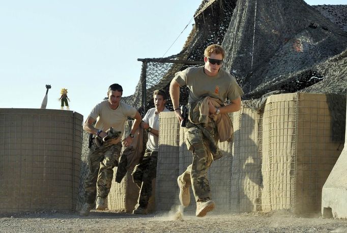 Britain's Prince Harry (L) races out from the VHR (very high ready-ness) tent with fellow crew members, to scramble his Apache helicopter at Camp Bastion, southern Afghanistan in this photograph taken November 3, 2012, and released January 21, 2013. The Prince, who is serving as a pilot/gunner with 662 Squadron Army Air Corps, is on a posting to Afghanistan that runs from September 2012 to January 2013. Photograph taken November 3, 2012. REUTERS/John Stillwell/Pool (AFGHANISTAN - Tags: MILITARY POLITICS SOCIETY ROYALS CONFLICT) Published: Led. 21, 2013, 9:42 odp.