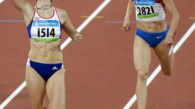 Zuzana Hejnová s vítězným gestem po přeskočení cílové čáry před Ruskou běžkyní Irinou Obedinaovou v semifinálovém běhu na 400 metrů překážek na Národním stadionu v Pekingu.