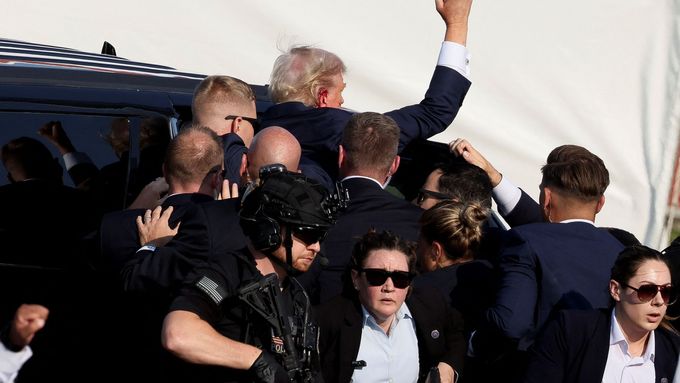 Zranění Donald Trump je eskortován z pódia.