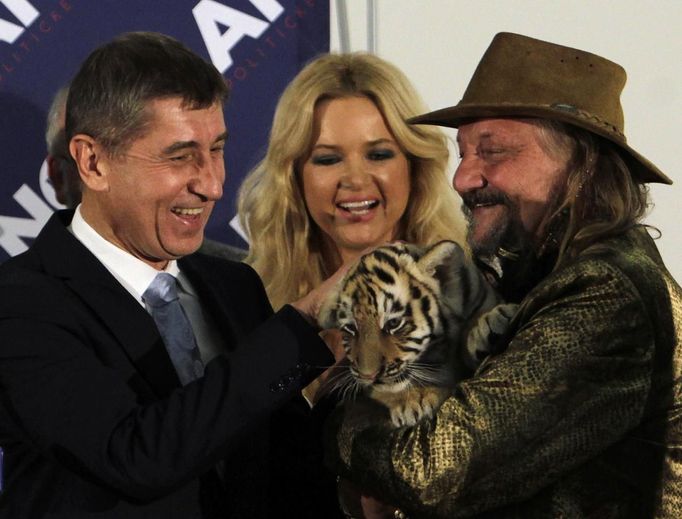 Circus owner Jaromir Joo (R) holds a tiger cub as he congratulates Andrej Babis (L), leader of the ANO movement