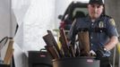 Seattle Police Officer Leyba carries a trash can full of guns during the gun buyback event in Seattle, Washington January 26, 2013. Participants received up to a $100 gift card in exchange for working handguns, shotguns and rifles, and up to a $200 gift card for assault weapons. The event lasted from 9 a.m. until shortly after noon, after the event ran out of $80,000 worth of gift cards. REUTERS/Nick Adams (UNITED STATES - Tags: POLITICS CIVIL UNREST) Published: Led. 27, 2013, 12:47 dop.