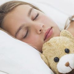 Dívka s plyšákem spí