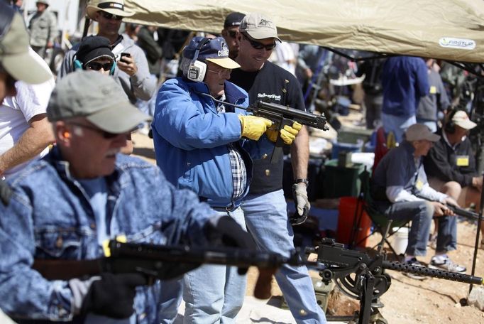 Shooters fire their weapons during the Big Sandy Shoot in Mohave County, Arizona March 23, 2013. The Big Sandy Shoot is the largest organized machine gun shoot in the United States attended by shooters from around the country. Vintage and replica style machine guns and cannons are some of the weapons displayed during the event. Picture taken March 22, 2013. REUTERS/Joshua Lott (UNITED STATES - Tags: SOCIETY) Published: Bře. 25, 2013, 3:35 odp.