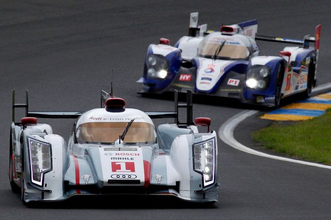 Andre Lotterer of Germany drives his Audi R18 E-Tron Quattro just ahead of the Toyota TS030 Hybrid car driven by France's Nicolas Lapierre during the Le Mans 24-hour spor