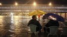 People sit on chairs in a flooded St Mark's Square at night during a period of seasonal high water in Venice November 1, 2012. The water level in the canal city rose to 140 cm (55 inches) above normal, according to the monitoring institute. REUTERS/Manuel Silvestri (ITALY - Tags: ENVIRONMENT SOCIETY TRAVEL DISASTER) Published: Lis. 1, 2012, 8:05 dop.