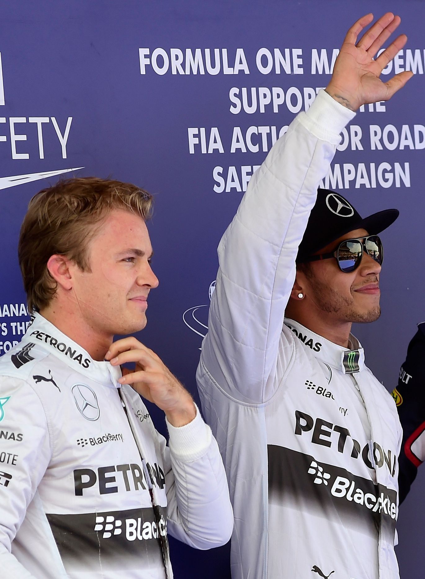 Mercedes Formula One driver Hamilton of Britain gestures after taking the pole position, accompanied by second-fastest teammate Rosberg of Germany, at the qualifying session of the Spanish F1 Grand Pr